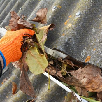 Man Cleaning Gutters in the fall